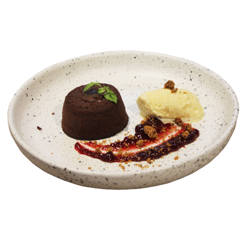 Homemade chocolate fondant made from scratch with rich local cocoa, served with creamy homemade vanilla ice cream, a zesty homemade lime crumble, and a tangy red fruits coulis.